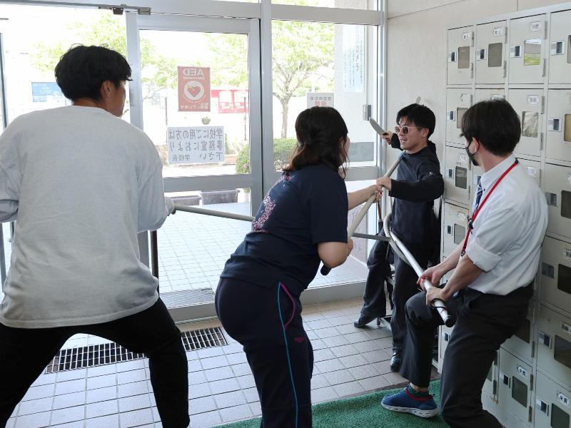 不審者役を取り押さえる教職員