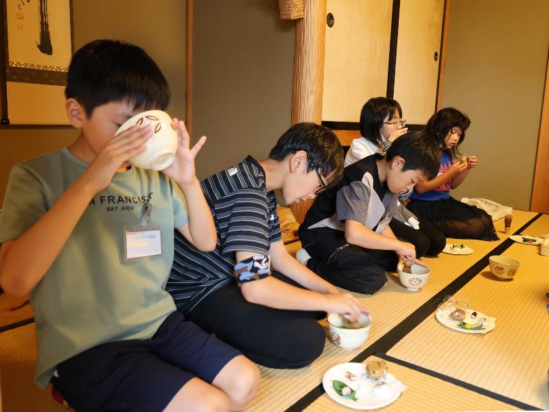 お茶と和菓子を楽しむ児童ら