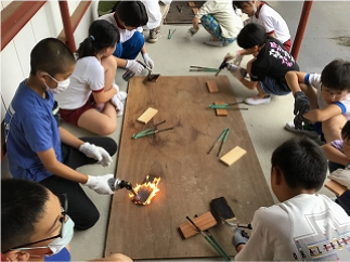 小学校の木工教室で児童が杉板で表札を作っている様子