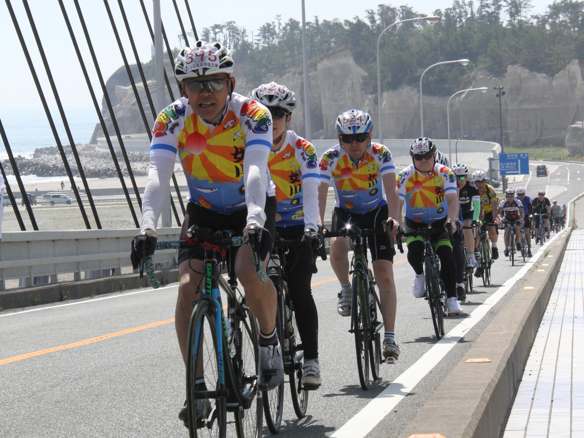 松川浦大橋をとおるサイクリング参加者たち
