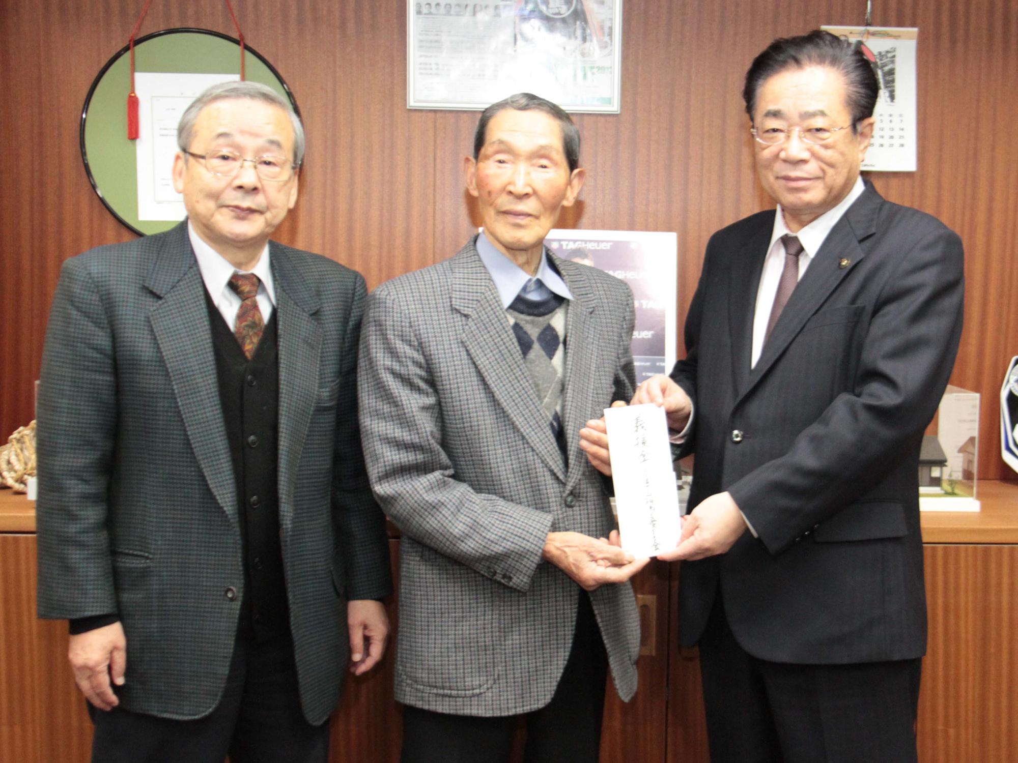 渡辺満州会長と鈴木博副会長が義援金を立谷市長に手渡す様子