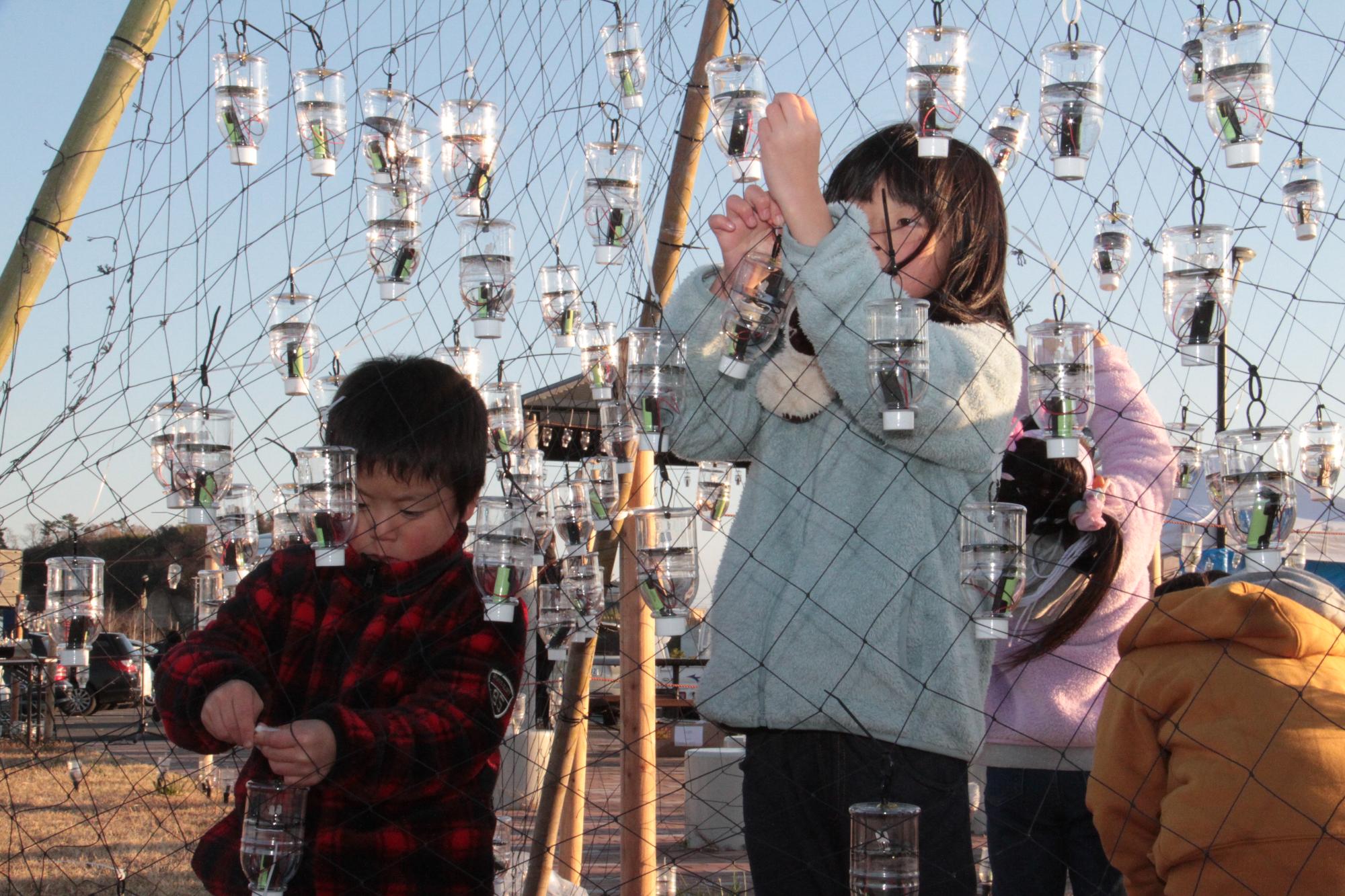 ペットボタルを飾り付ける子どもたち