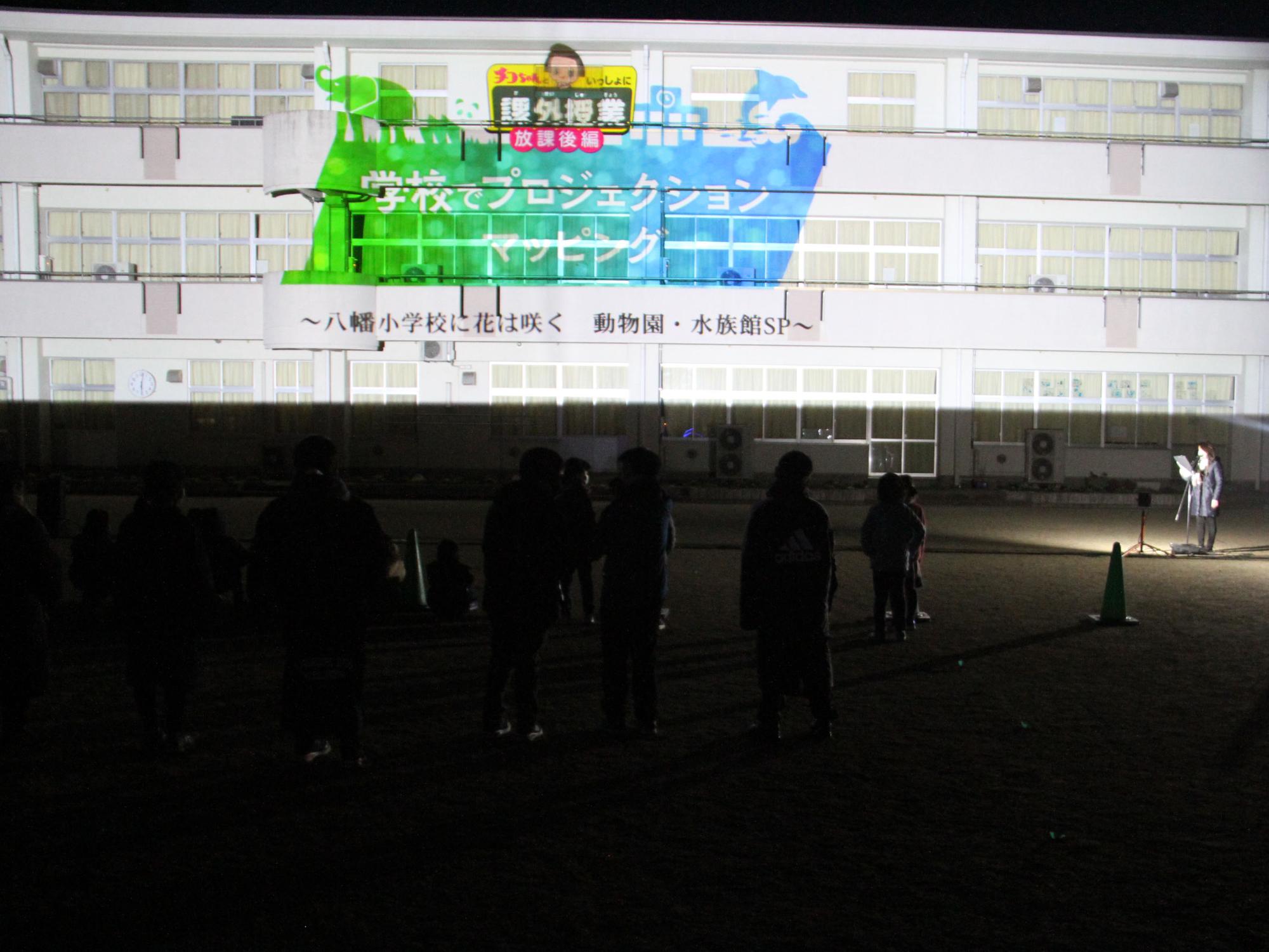 八幡小学校校舎のプロジェクションマッピングを投影している様子