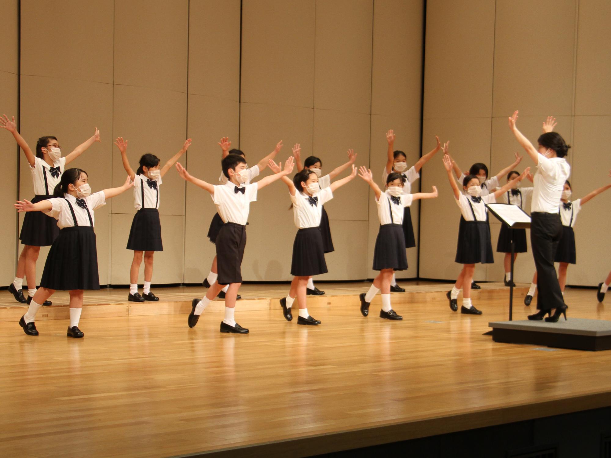 市民会館ステージで合唱を披露する桜丘小学校合唱部の児童らの様子