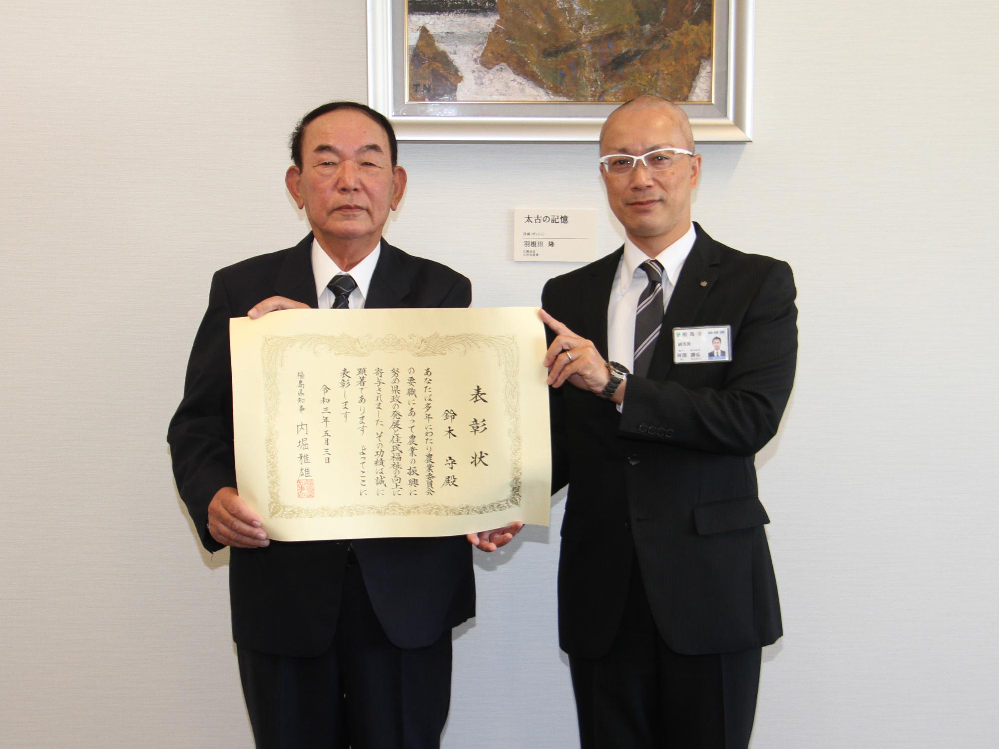 鈴木さんが農業功労者知事表彰の報告を阿部副市長にする様子