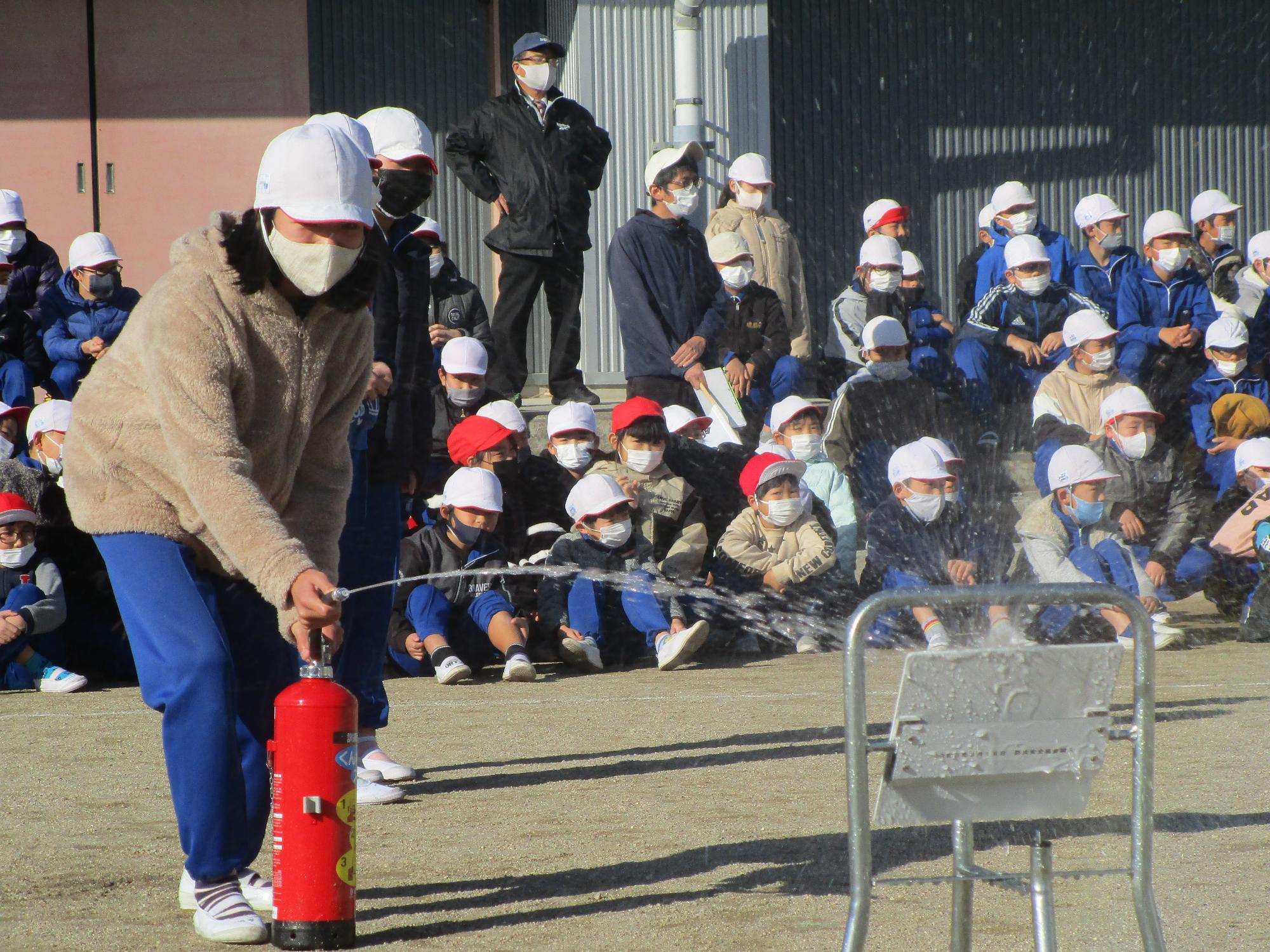 飯豊小学校避難訓練で初期消火のため水消火器を使用した訓練の様子