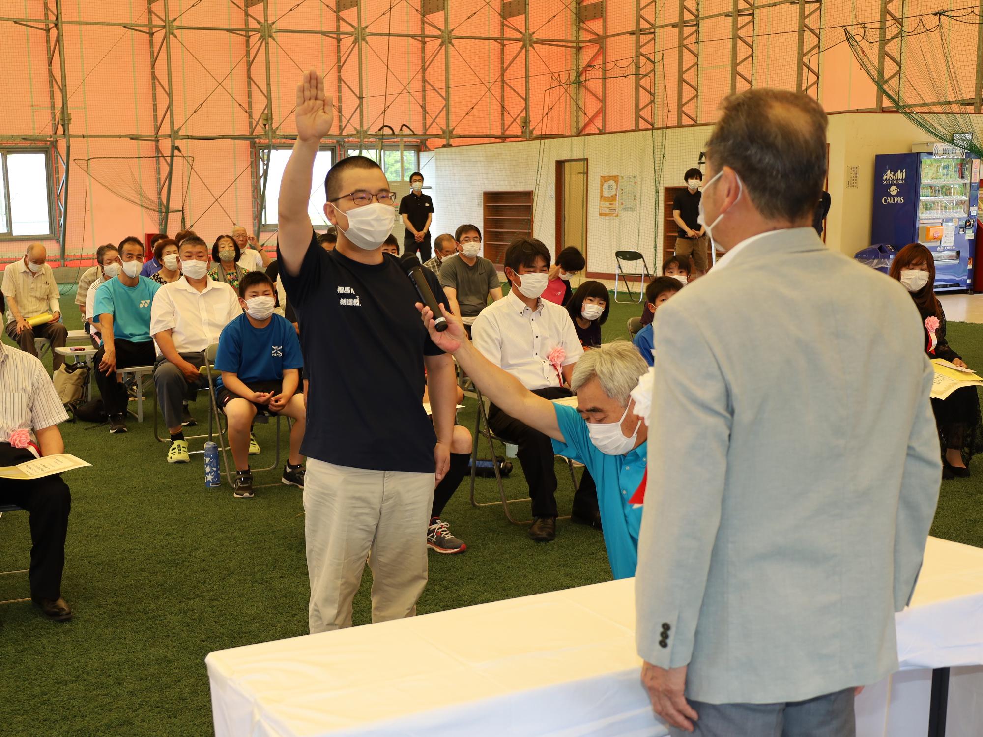 市民体育祭総合開会式で、西村選手が阿部市体育協会会長に対し選手宣誓を行う様子