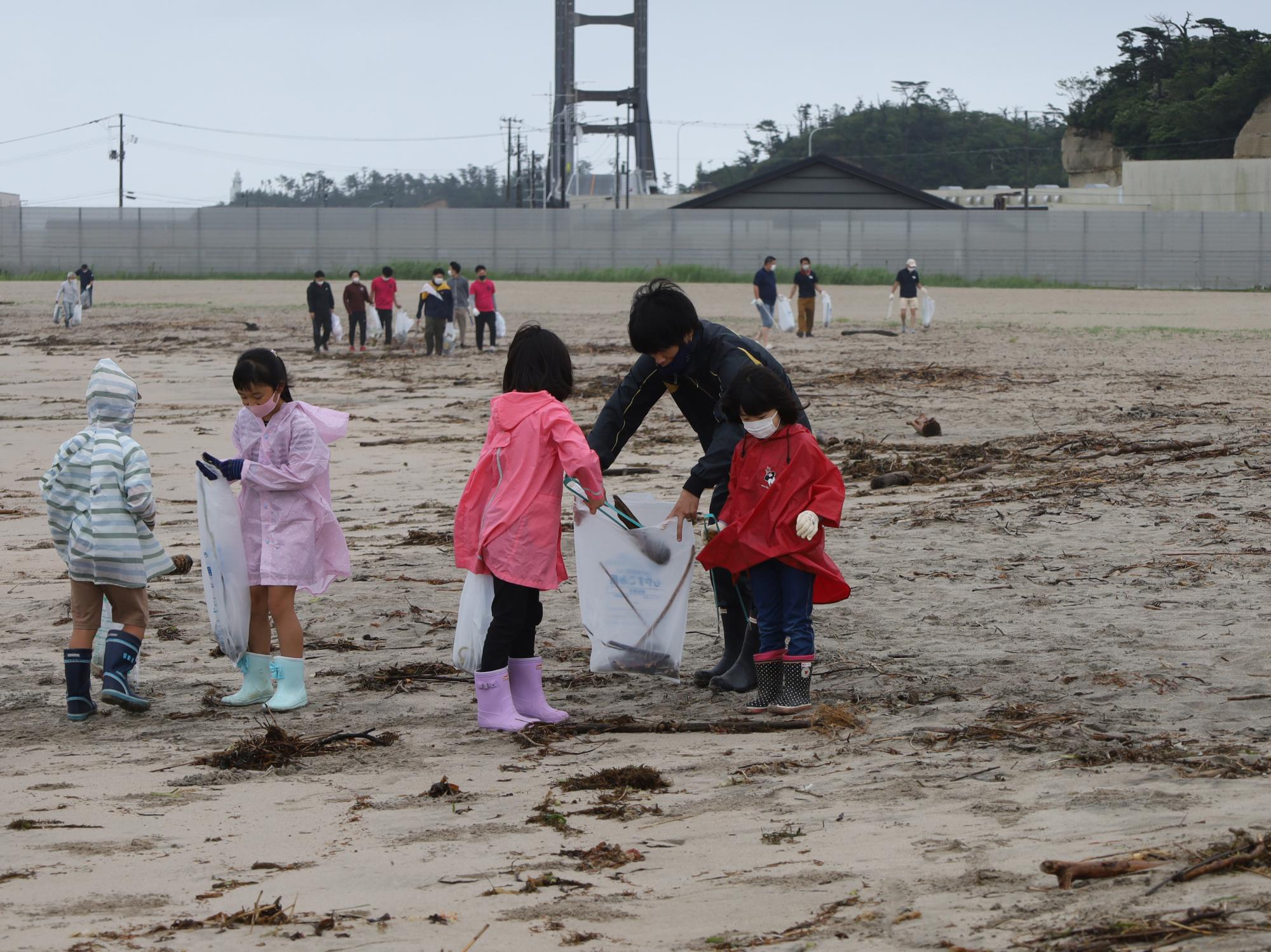 原釜尾浜海水浴場クリーンアップ作戦で、参加者らがきれいな砂浜にするため清掃する様子