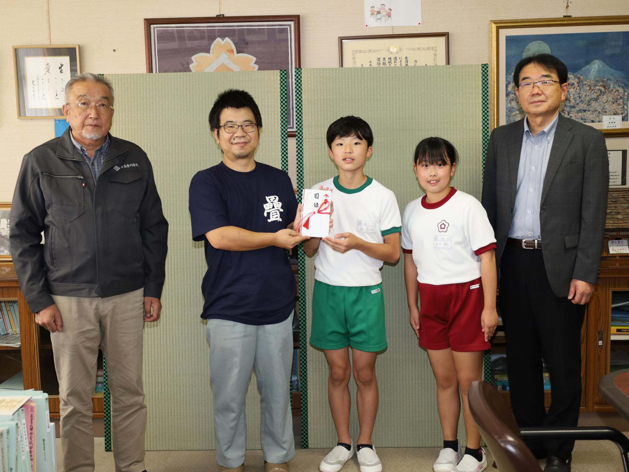 桜丘小学校の児童らが福島県畳業工業組合から畳の寄付を受ける様子