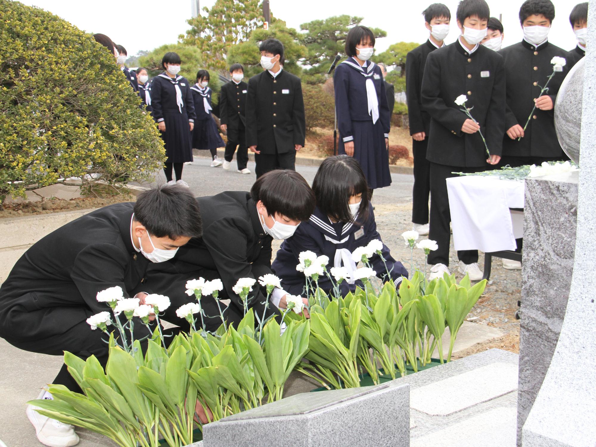 磯部中学校慰霊式で生徒らが献花をする様子