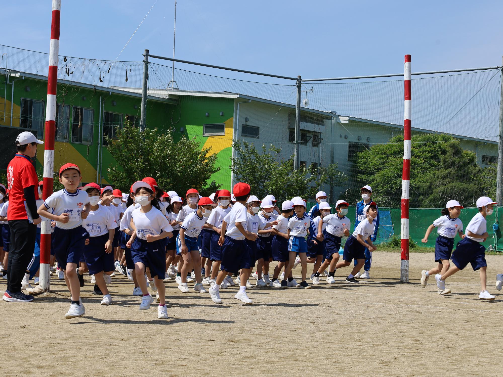 中村第一小学校スポーツフェスティバルで競技に臨むため校庭に入場する児童の様子