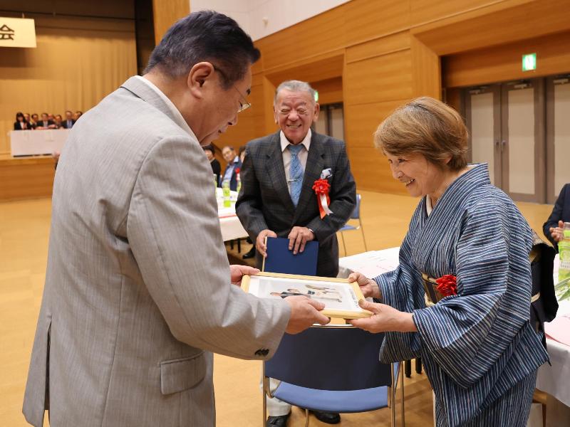 招待者席を回り祝い状を手渡す様子