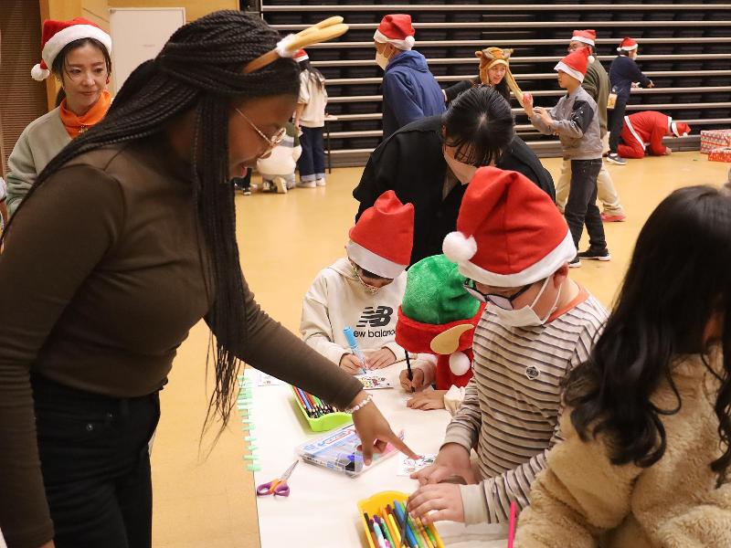 クリスマスオーナメント作りをする外国人ボランティアと子どもたち