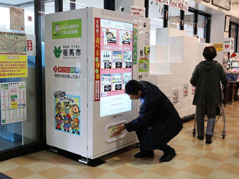 ふるさと納税自動販売機を利用する様子