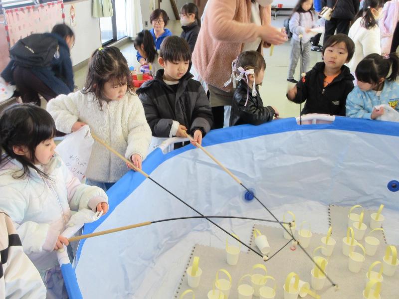 釣り竿でおみくじを釣る児童
