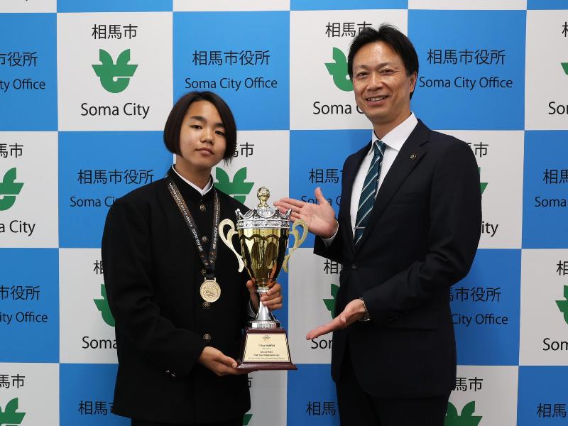 優勝杯を披露する様子