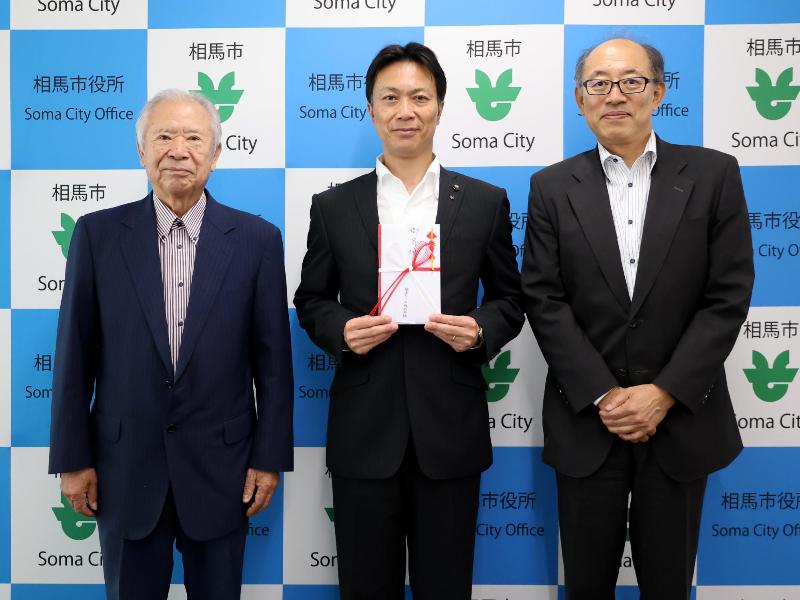 寄付金を受け取る様子