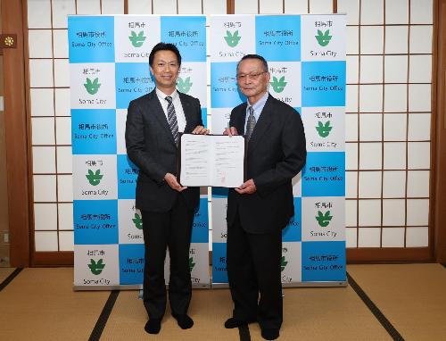 阿部相馬市長と只野相馬市社会福祉協議会会長が連携協定書を取り交わす一面